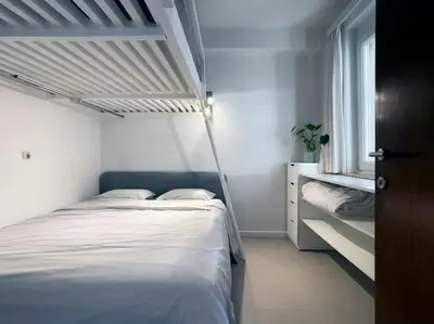 a white bedroom with a bed and a window at Cosy apartment for 2p-4p Ghent in Ghent