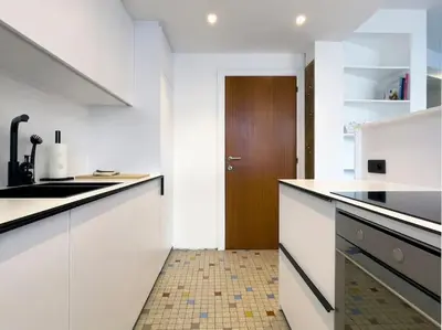 a kitchen with white counters and a brown door at Cosy apartment for 2p-4p Ghent in Ghent