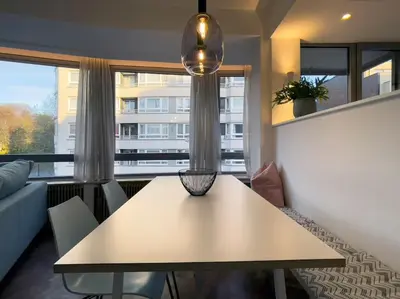 a table in a living room with a large window at Cosy apartment for 2p-4p Ghent in Ghent