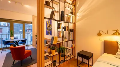 a room with a book shelf and a bed and a table at Pacific Residences - Studio in Antwerp