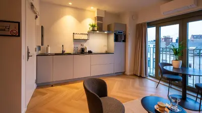a kitchen and dining room with a table and chairs at Pacific Residences - Studio in Antwerp