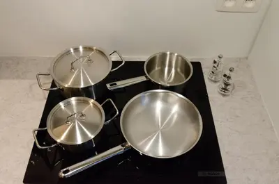 three pots on top of a stove in a kitchen at Pacific Residences - Studio in Antwerp