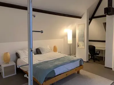 a bedroom with a bed and a desk and a chair at Appartement séparé avec parking dans villa in Vilvoorde