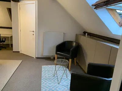 a room with a black chair and a table at Appartement séparé avec parking dans villa in Vilvoorde