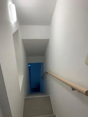 a staircase in a building with a stair railing at Appartement séparé avec parking dans villa in Vilvoorde