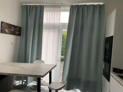 a table and chairs in a room with a window at Appartement séparé avec parking dans villa in Vilvoorde