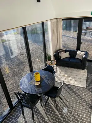 a room with a table and chairs and a couch at The Conservatory, a cosy holiday home located central between Gent Antwerpen & Brussel in Lokeren
