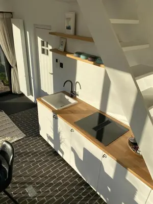 a kitchen with a sink and a counter at The Conservatory, a cosy holiday home located central between Gent Antwerpen & Brussel in Lokeren