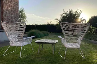two chairs and a table in a yard at The Conservatory, a cosy holiday home located central between Gent Antwerpen & Brussel in Lokeren