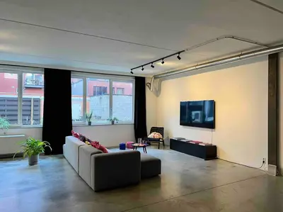 a living room with a couch and a tv at Loft Antwerp - Eilandje in Antwerp