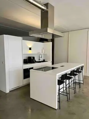a kitchen with a white counter and stools at Loft Antwerp - Eilandje in Antwerp