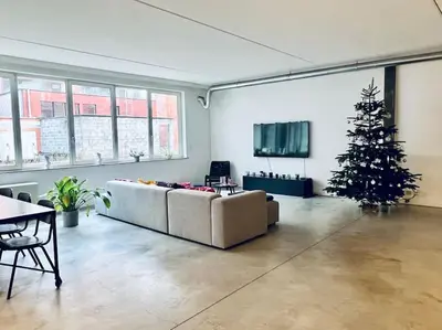 a living room with a christmas tree and a couch at Loft Antwerp - Eilandje in Antwerp