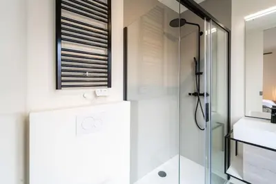a bathroom with a glass shower and a sink at Beautiful 1BR apartment in Antwerp in Antwerp