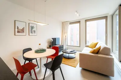 a living room with a table and chairs and a couch at Beautiful 1BR apartment in Antwerp in Antwerp