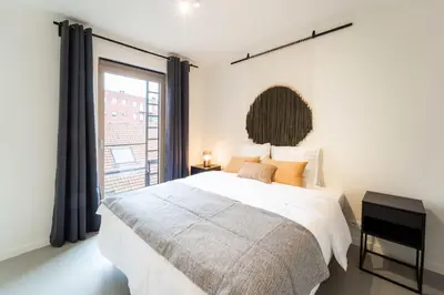 a bedroom with a large bed and a large window at Beautiful 1BR apartment in Antwerp in Antwerp