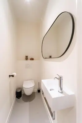 a white bathroom with a sink and a mirror at Apartments in Antwerp South in Antwerp