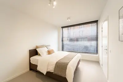 a bedroom with a bed and a large window at Apartments in Antwerp South in Antwerp