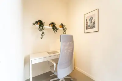 a white desk with a chair next to a table at Apartments in Antwerp South in Antwerp
