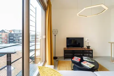 a living room with a couch and a tv and a window at Apartments in Antwerp South in Antwerp