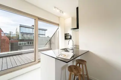 a kitchen with a counter and a large window at Apartments in Antwerp South in Antwerp