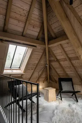 a attic room with a bench and a window at Etablo B&B in Bornem