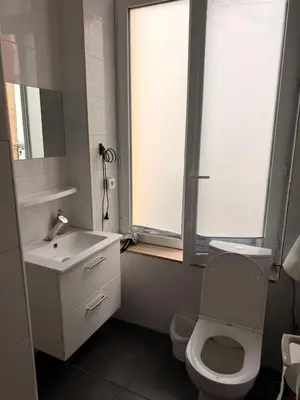 a bathroom with a toilet and a sink and a window at Sweet Dream House in Brussels