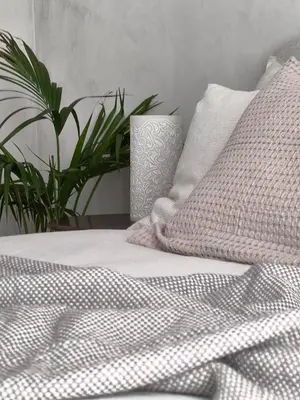 a bedroom with a bed with white sheets and a plant at Stunning Riverview apartment in Antwerp