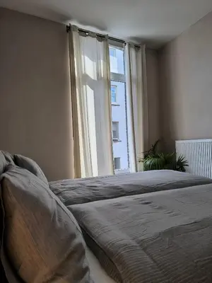 a bedroom with a bed and a large window at Stunning Riverview apartment in Antwerp