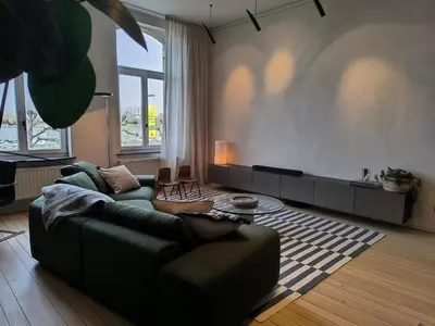 a living room with a couch and a table at Stunning Riverview apartment in Antwerp
