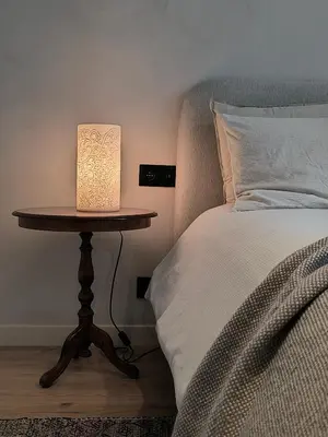 a table with a lamp on it next to a bed at Stunning Riverview apartment in Antwerp