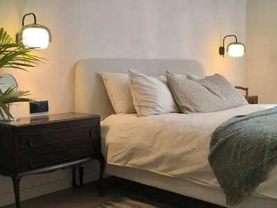 a bed with two pillows and a night stand with a nightstand at Stunning Riverview apartment in Antwerp