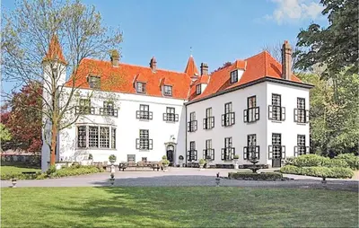 a large white building with a red roof at Kasteel Ter Leyen in Assenede