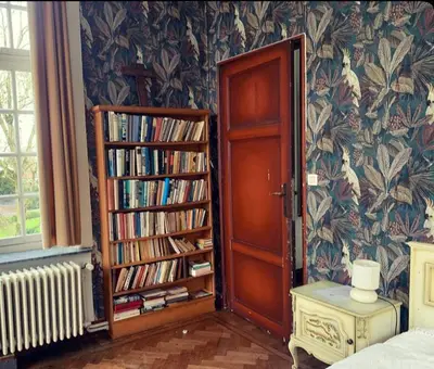 a room with a book shelf with books and a door at Kasteel Ter Leyen in Assenede