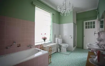 a bathroom with a tub and a toilet and a window at Kasteel Ter Leyen in Assenede