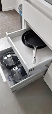 a drawer in a white cabinet with two plates at Huis ALNA 5 in Mechelen