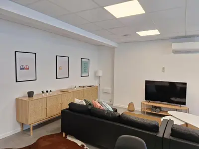 a living room with a couch and a flat screen tv at Huis ALNA 5 in Mechelen