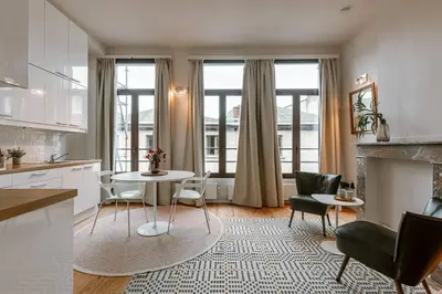 a kitchen and living room with a table and chairs at Charming mansion in vibrant Antwerp in Antwerp