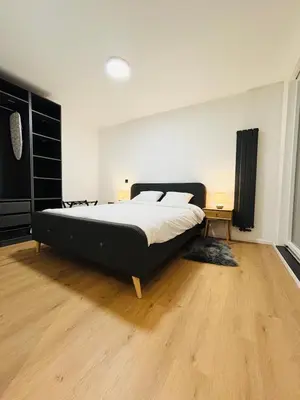 a bedroom with a large bed and a wooden floor at Cozy Flat in Brussels