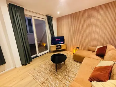 a living room with a couch and a tv at Cozy Flat in Brussels