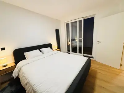 a bedroom with a large white bed and a window at Cozy Flat in Brussels