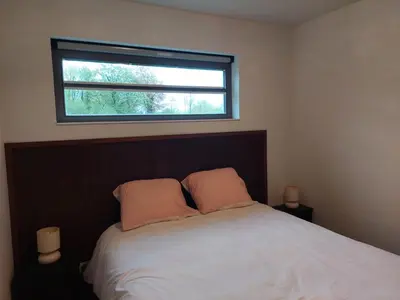a bedroom with a bed with two pillows and a window at Vakantiewoning Nieuwdonk in Berlare