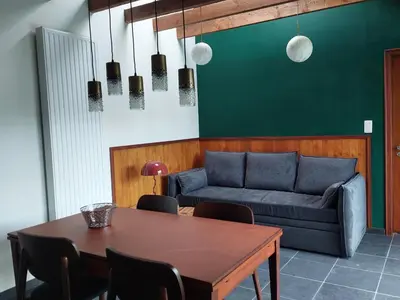 a living room with a table and a couch at Vakantiewoning Nieuwdonk in Berlare