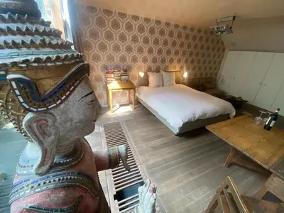 a room with a bedroom with a bed and a table at Schopenhauer in Ghent