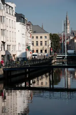 a bridge over a river in a city with buildings at Schopenhauer in Ghent