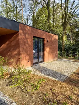 a brick house with a large glass door at Starling in Oud-Turnhout