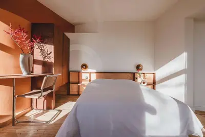 a bedroom with a white bed and a chair at Your colourful Antwerp Oasis in Antwerp