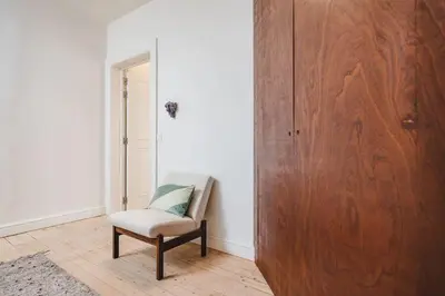 a room with a chair and a wooden door at Your colourful Antwerp Oasis in Antwerp
