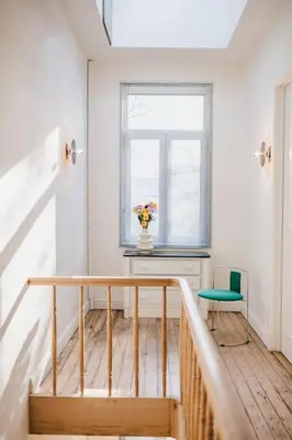 a staircase with a table and a vase of flowers at Your colourful Antwerp Oasis in Antwerp