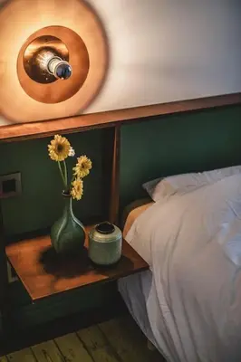 a bedroom with a bed with a vase with flowers on a table at Your colourful Antwerp Oasis in Antwerp