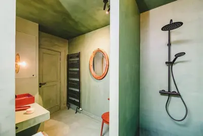 a bathroom with a shower and a mirror on the wall at Your colourful Antwerp Oasis in Antwerp